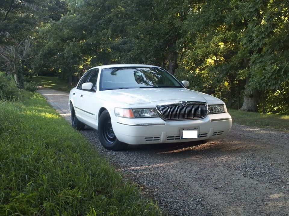 White 2000 Mercury Grand Marquis parked on a gravel road