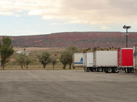 1992 Ford Taurus - Semi-truck trailers are parked in a lot with a red mesa and cloudy sky in the background.