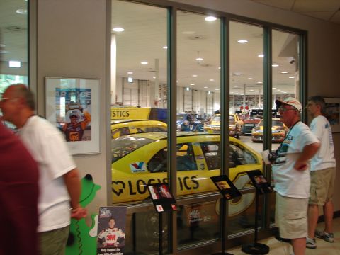 1992 Ford Taurus - Several race cars are on display inside a building, with visitors observing them.