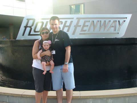 1992 Ford Taurus - A family stands before the ROUSH FENWAY sign, likely at an event or dealership.