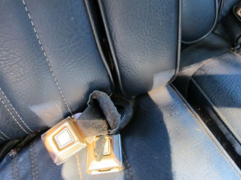 1991 Ford LTD Crown Victoria - The interior of a car shows a close-up view of a seat belt buckle.