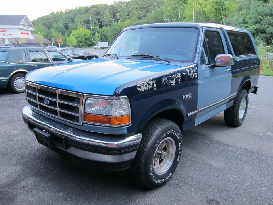 Blue and dark blue Ford Bronco with peeling paint on fender