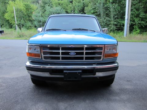 2001 Ford Crown Victoria - Frontal view of a blue 1997 Ford F-250 pickup truck parked on asphalt.