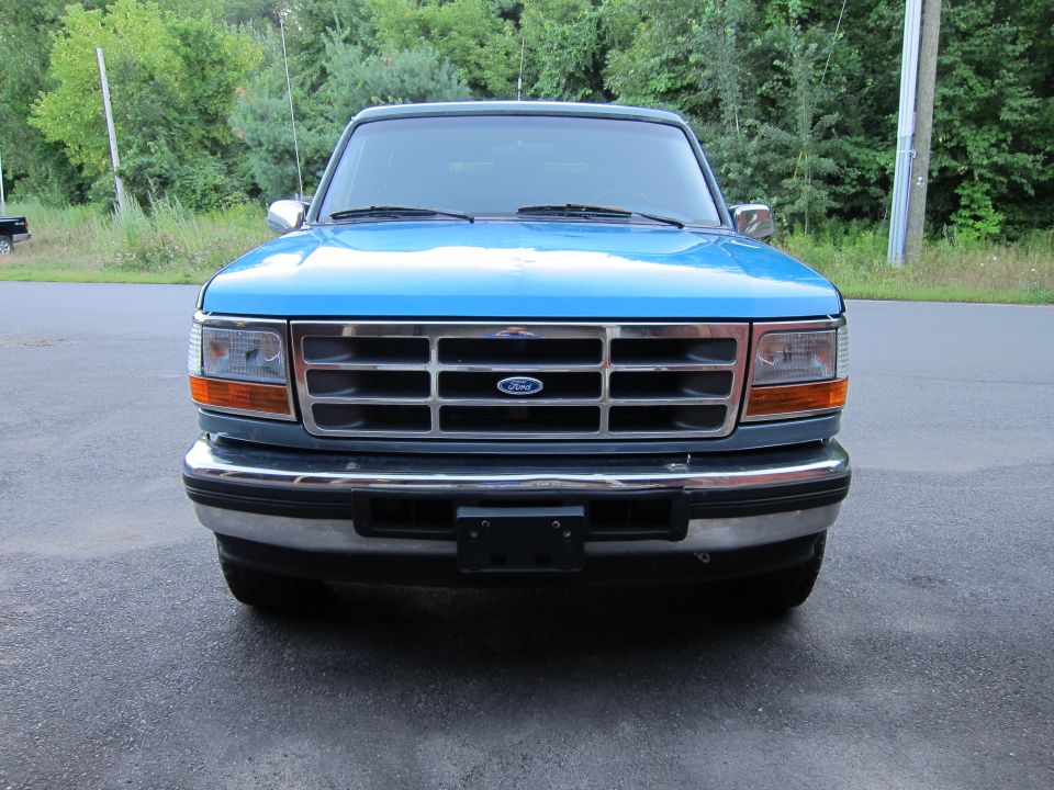 Front view of a blue 1997 Ford F-250 truck with a chrome grille and bumper
