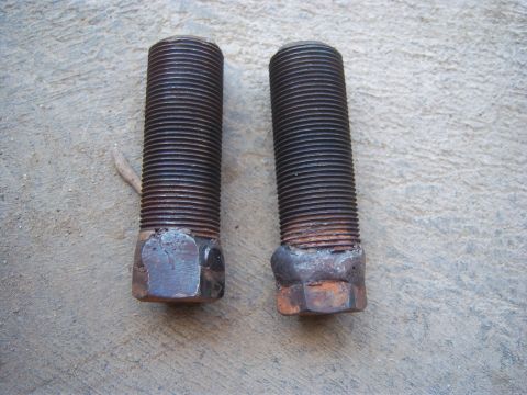 1996 Ford Bronco - Close-up of two heavily rusted bolts, likely for automotive use.