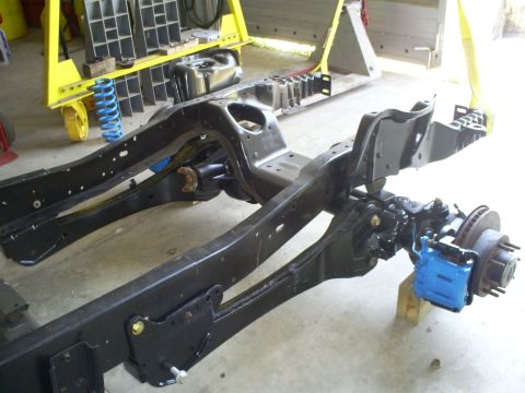 1992 Ford Bronco - The chassis of a vehicle is shown with suspension components and a brake assembly.