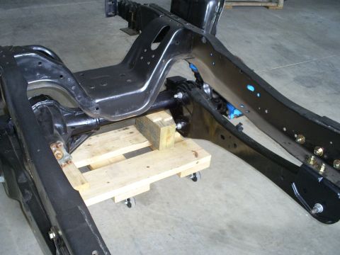 1992 Ford Bronco - Close-up view of a vehicle's chassis and suspension components, disassembled and on a pallet.