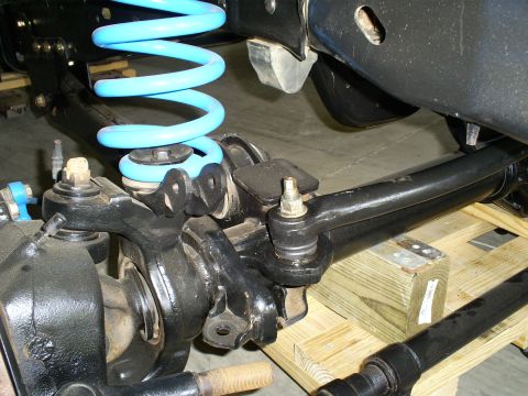 1992 Ford Bronco - This image shows the front suspension components of a vehicle, including a bright blue coil spring.