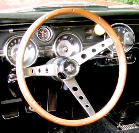 1967 Mercury Cougar - The interior of a 1967 Mercury Cougar, a classic wood-rimmed steering wheel and dashboard gauges.