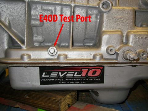 1990 Ford Bronco - Close-up of a transmission pan showing a Level 10 sticker and an E4OD test port indicator.