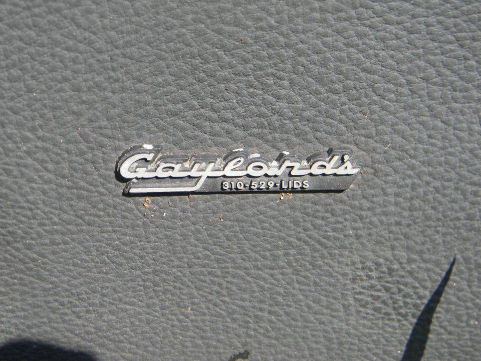 Close-up of a Gaylord's Lids emblem with phone number 310-529-LIDS on a textured surface