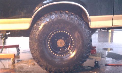 1990 Ford Bronco - Close-up of a vehicle's side, focusing on a large off-road tire and fender assembly.