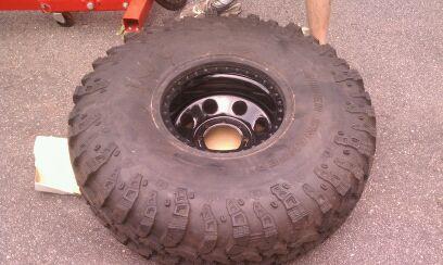 1990 Ford Bronco - A large off-road tire and wheel is shown, with the Supermotors.net logo visible in the lower right corner.