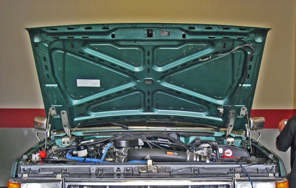 1990 Ford Bronco engine bay with hood open, showing engine and intake system