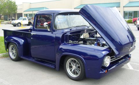 2007 Ford Mustang - A restored blue 1956 Ford F-100 pickup truck is displayed with its hood open, revealing the engine.