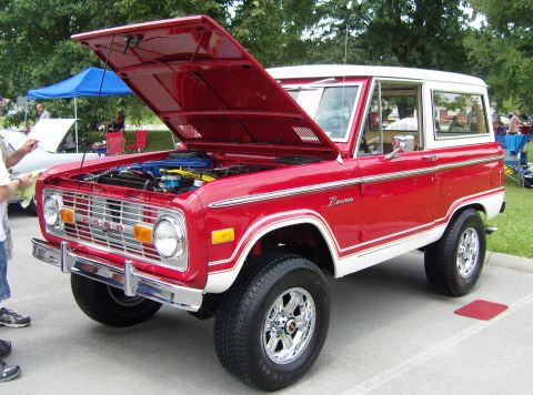 2007 Ford Mustang - A classic red and white Ford Bronco is displayed with its hood up, revealing the engine bay.