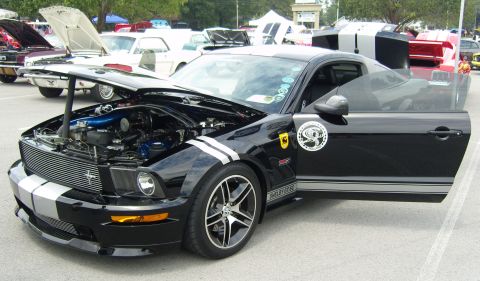 2007 Ford Mustang - A black 2007 Ford Mustang Shelby GT500 is displayed with its hood and driver's door open, revealing the engine and interior.