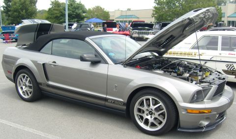 2007 Ford Mustang - Silver 2007 Ford Mustang GT500 convertible at a car show, hood up revealing the engine.