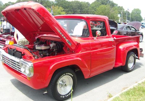2007 Ford Mustang - A classic red Ford pickup truck is displayed with its hood open, revealing the engine compartment.