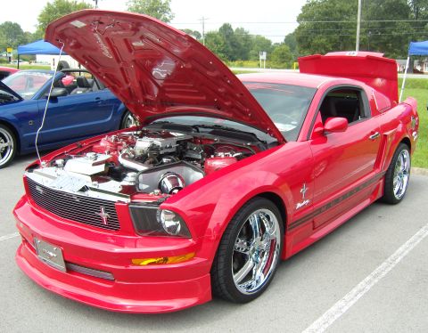 2007 Ford Mustang - A red Ford Mustang is parked with its hood and trunk open, displaying its engine and rear spoiler.