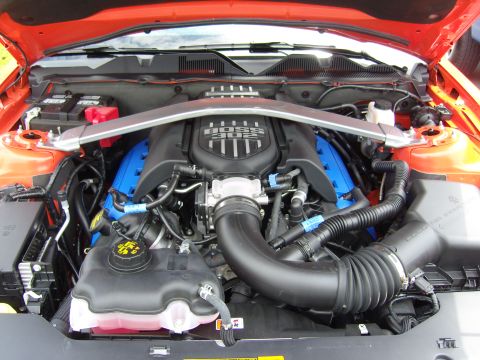 2007 Ford Mustang - The engine bay of a Ford Mustang features a "BOSS 302" engine cover and bright blue valve covers.