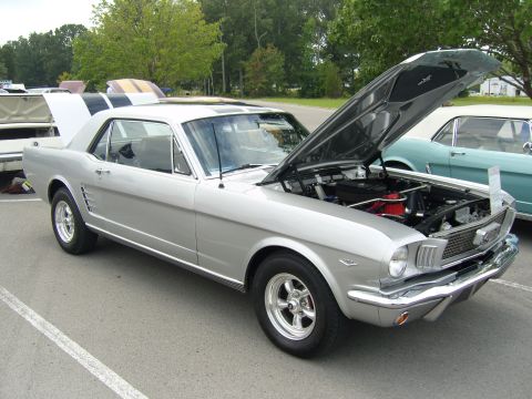 2007 Ford Mustang - A silver 1965 Ford Mustang coupe is displayed with its hood open, revealing the engine bay.