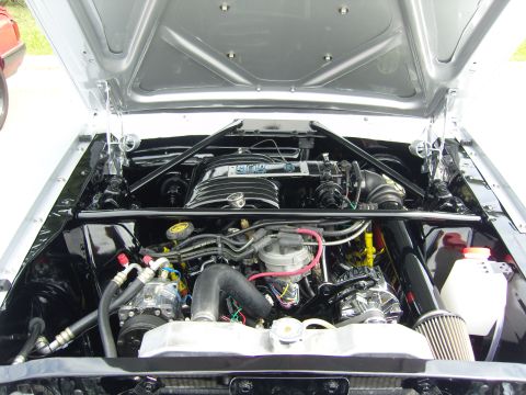 2007 Ford Mustang - The engine bay of a classic Ford, a prominent intake with 'FORD' branding and polished chrome components.
