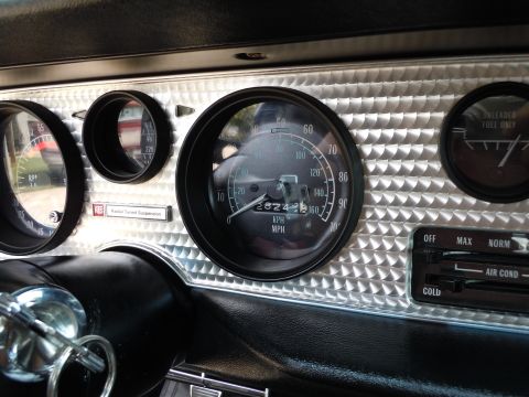 1976 Pontiac Trans Am - Close-up of a car's interior dashboard, highlighting the speedometer and other gauges.