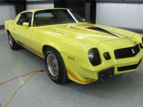 1976 Pontiac Trans Am - This yellow 1977 Pontiac Firebird features distinctive racing stripes on its hood and body.