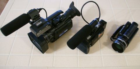 1993 Ford Taurus - Three video cameras are arranged on a tiled surface, each equipped with a microphone and lens.
