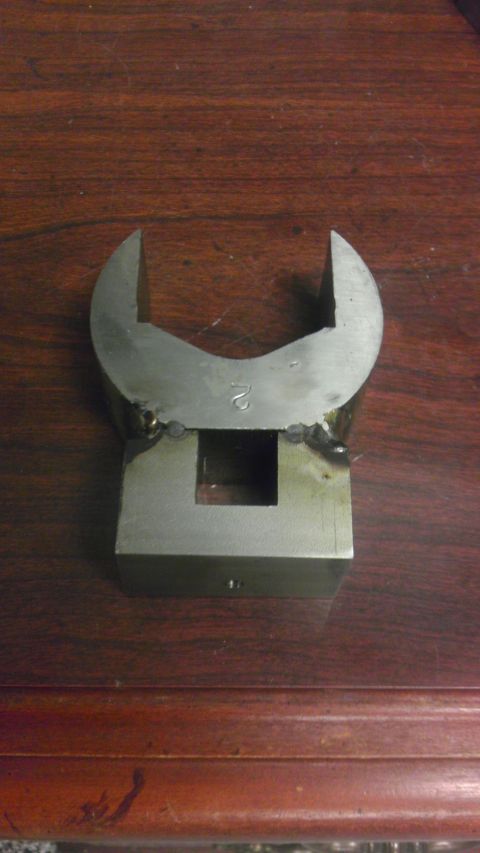 1989 Ford Bronco - A metal tool part, possibly a wrench head or adapter, is shown against a wooden background. A number '2' is visible on the part.