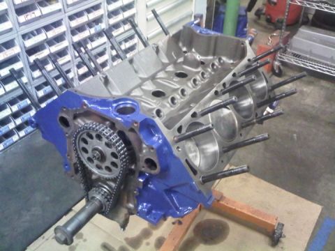 1979 Ford Bronco - Assembled V8 short block on an engine stand in a shop, painted Ford blue on the outside with bare machined deck surfaces and pistons visibl…