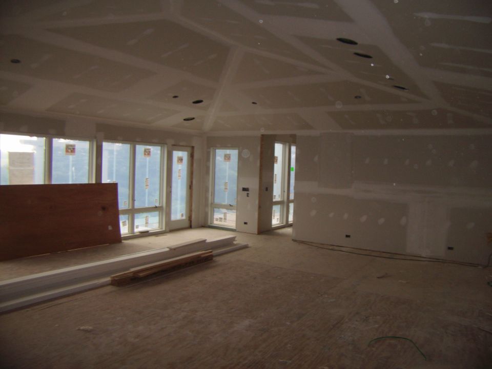 Interior of a house under construction, with drywall up and windows installed