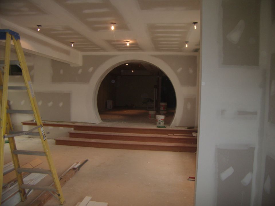 interior construction with a ladder, drywall, and a circular doorway