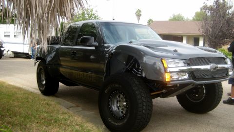 1996 Ford Bronco - This heavily modified pickup truck features an aftermarket hood and fender flares, suggesting it's built for off-road use.