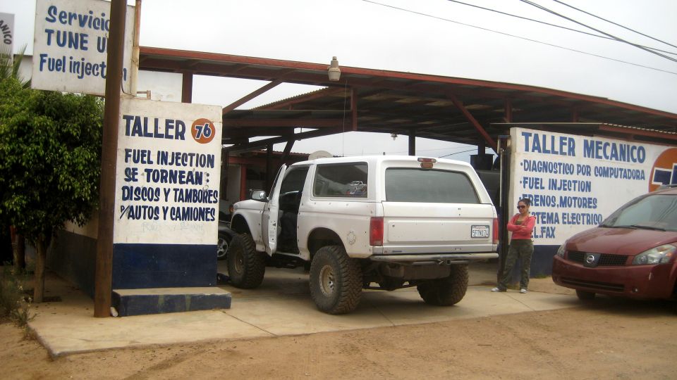 White 1996 Ford Bronco parked at a mechanic shop, rear view