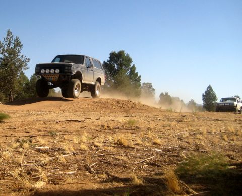 1996 Ford Bronco - Modified Ford Bronco airborne over a dirt hill during an off-road excursion.