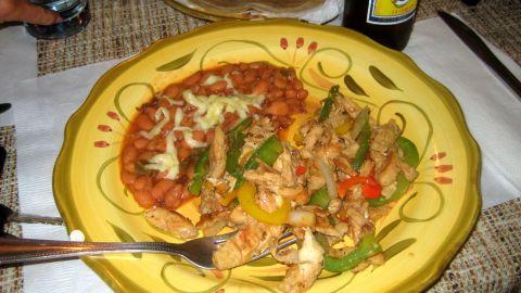 1996 Ford Bronco - A plate of chicken fajitas and beans is ready to be eaten, with a bottle of beer in the background.