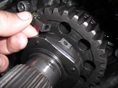 1991 Ford Bronco - Hand adjusting a shift fork on a transfer case gear assembly.