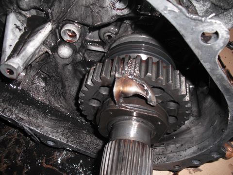 1991 Ford Bronco - This transfer case gear has broken teeth and bent metal, indicating significant internal damage.