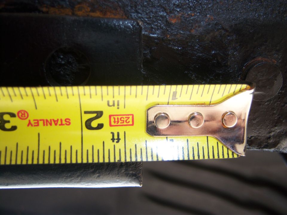 Stanley tape measure reading approximately 2.5 inches against a black metal surface
