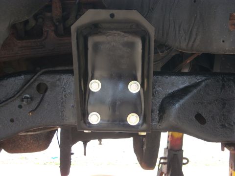 1996 Ford Bronco - Close-up view of a black metal bracket attached to the underside of a vehicle frame.