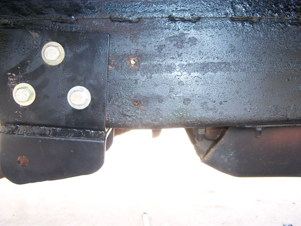 Close-up of rusty vehicle frame with bolts and brackets