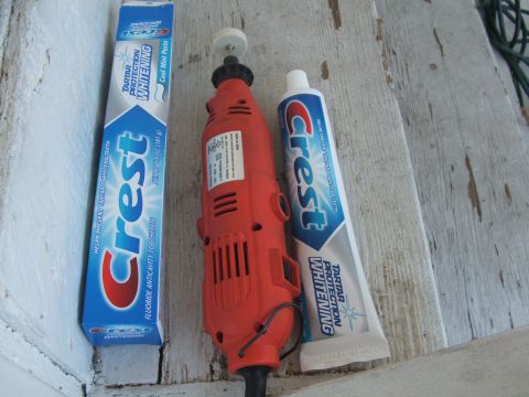 1995 Ford Bronco - Rotary tool and Crest toothpaste are laid out on a wooden surface.