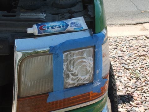 1995 Ford Bronco - A tube of Crest toothpaste is used to polish a vehicle's headlight, with blue tape surrounding the area.