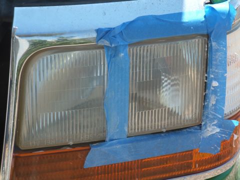 1995 Ford Bronco - Headlights on a 1995 Ford Bronco are masked with blue tape, likely in preparation for a paint or restoration project.