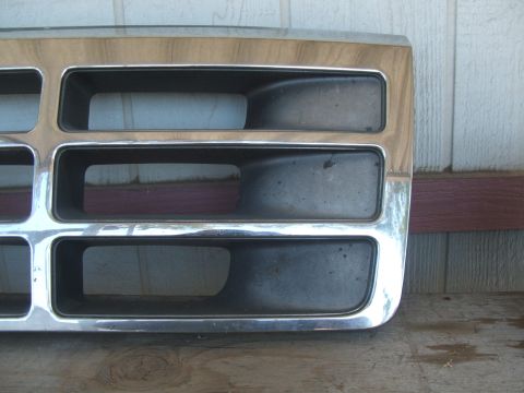 1995 Ford Bronco - A close-up of a vehicle's front grille, chrome trim and wood-grain accents.