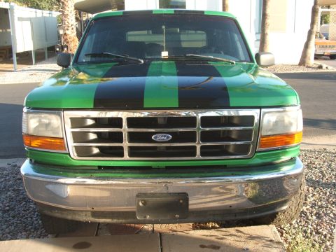 1995 Ford Bronco - This 1995 Ford Bronco features a distinctive green paint job with bold black racing stripes.