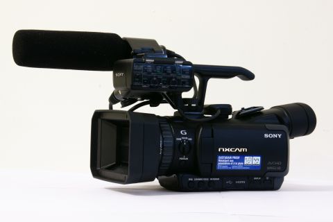 1993 Ford Taurus - Sony NXCAM camcorder with microphone and lens, photographed against a white background.