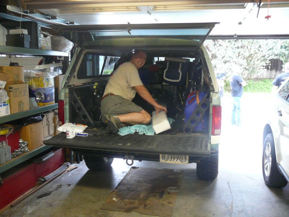 Man loading box into 1988 Ford Bronco bed. License plate BJ39903